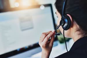 Servicemedewerker met headset in gesprek met een klant